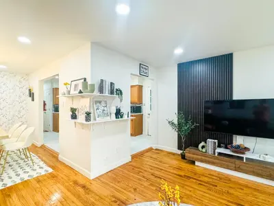 a living room with a large flat screen tv at Lux Designer Home with Gaming Rm in Jersey City