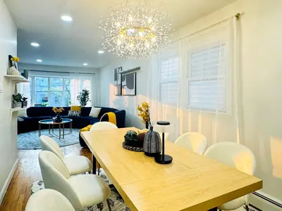 a living room with a dining room table and chairs at Lux Designer Home with Gaming Rm in Jersey City