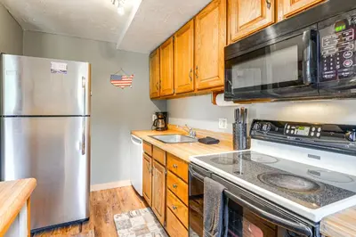 a kitchen with a stainless steel refrigerator and a microwave at West Dover Townhome Hot Tub, 2 Mi to Mount Snow! in West Dover