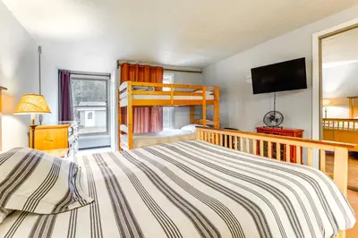 a bedroom with a bunk bed and a television at West Dover Townhome Hot Tub, 2 Mi to Mount Snow! in West Dover