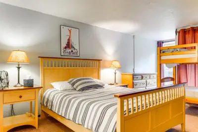 a bedroom with a bed and a bunk bed at West Dover Townhome Hot Tub, 2 Mi to Mount Snow! in West Dover