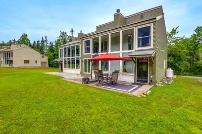 a house with a patio and a red umbrella at West Dover Townhome Hot Tub, 2 Mi to Mount Snow! in West Dover