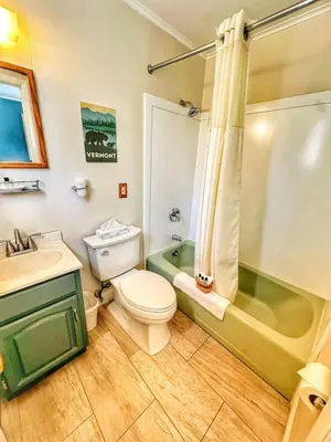 a bathroom with a toilet and a sink and a tub at Brittany Motel in Sunderland
