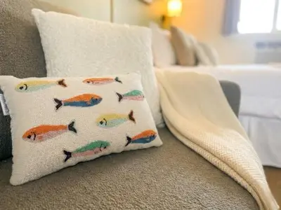 a pillow with fish on it sitting on a couch at Brittany Motel in Sunderland