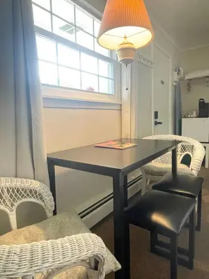 a dining room table with two chairs and a lamp at Brittany Motel in Sunderland