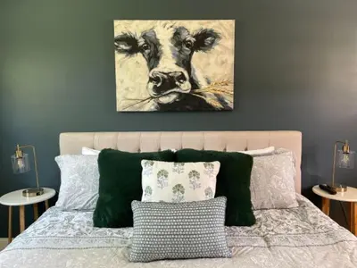 a bedroom with a bed with a painting of a cow at Brittany Motel in Sunderland