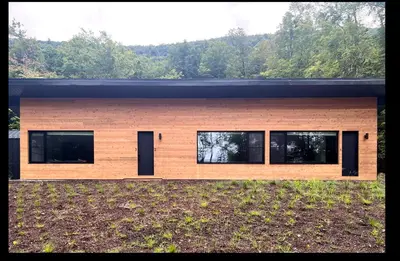 a house with a wooden facade with windows at Coldbrook Bed and Breakfast in Bearsville