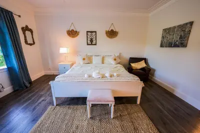 a bedroom with a large white bed and a chair at Solano Inn in Portland