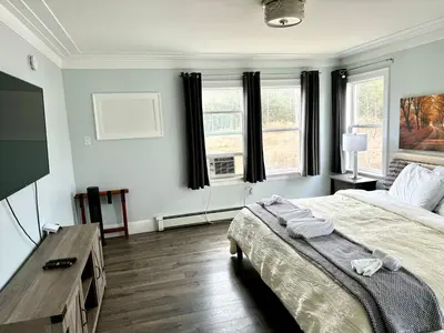 a bedroom with a large bed and two windows at Solano Inn in Portland