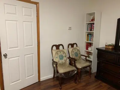 a room with two chairs and a book shelf at 2265 Bruckner Blvd Apartments in Bronx