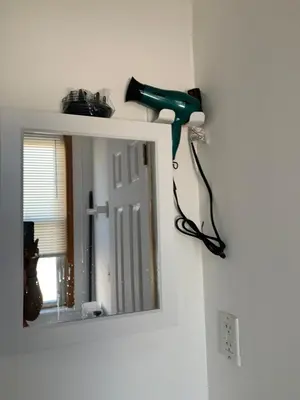 a blow dryer on a wall next to a mirror at 2265 Bruckner Blvd Apartments in Bronx