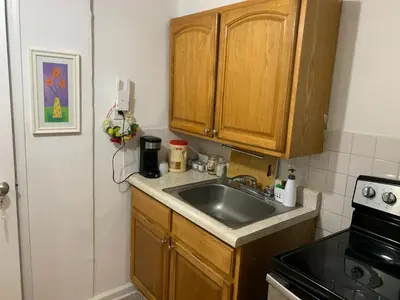 a kitchen with wooden cabinets and a sink at 2265 Bruckner Blvd Apartments in Bronx