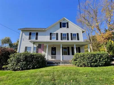 a white house with an american flag at Historic Colonial Pool Walk to Town in Litchfield