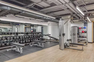 a gym with rows of dumbbells and weights at Blueground Midtown gym elev nr Grand Central NYC-1479 in New York
