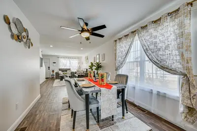a dining room with a table and chairs and a ceiling fan at 1 Mi to MGM Springfield Cozy Winter Duplex! in Springfield