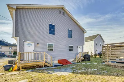 a large white house with a porch and a fence at 1 Mi to MGM Springfield Cozy Winter Duplex! in Springfield