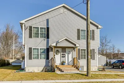 a white house with a front porch and stairs at 1 Mi to MGM Springfield Cozy Winter Duplex! in Springfield