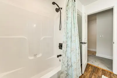 a bathroom with a shower curtain and a tub at 1 Mi to MGM Springfield Cozy Winter Duplex! in Springfield