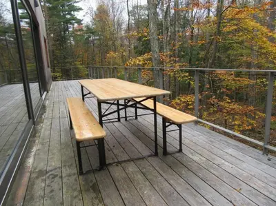 a wooden table and two benches on a deck at Modern Mountain Retreat in Mount Tremper