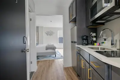 a kitchen with a sink and a bathroom with a tub at Cottage Suites in Middletown