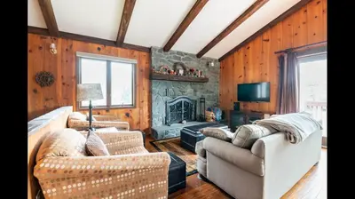 a living room with two couches and a stone fireplace at Beautiful Windham Chalet 2 minutes to the Mountain in Windham