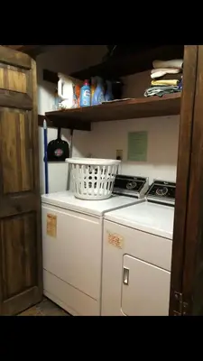 a small kitchen with a white laundry basket on top of a washing machine at Beautiful Windham Chalet 2 minutes to the Mountain in Windham