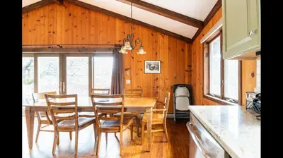 a dining room with a wooden table and chairs at Beautiful Windham Chalet 2 minutes to the Mountain in Windham