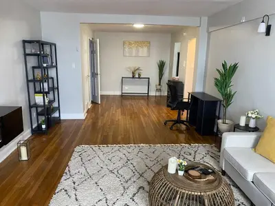 a living room with a couch and a table at Stylish- 1 bed room spacious APT in Corona