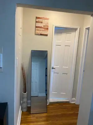 a hallway with a mirror and a white door at Stylish- 1 bed room spacious APT in Corona
