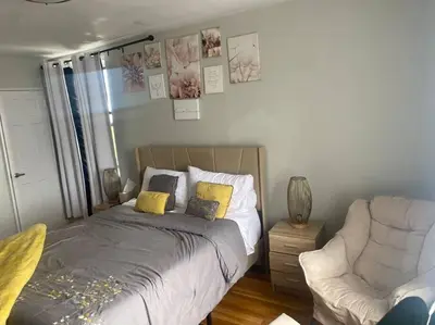 a bedroom with a bed and a couch and a chair at Stylish- 1 bed room spacious APT in Corona