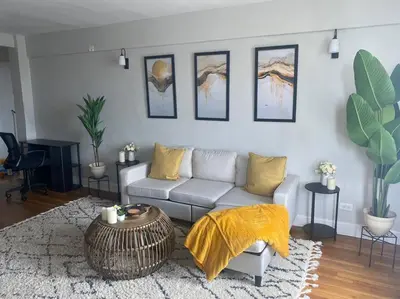 a living room with a couch and a table at Stylish- 1 bed room spacious APT in Corona