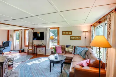 a living room with a couch and a table at Hawley Home with Deck and Mtn Views Swim, Ski and More! in Hawley