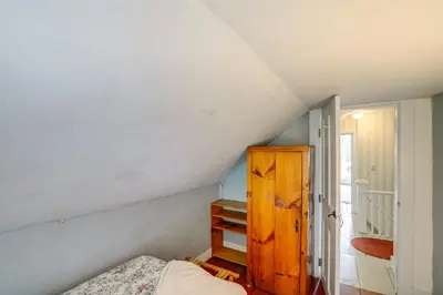 a attic room with a bed and a wooden cabinet at Hawley Home with Deck and Mtn Views Swim, Ski and More! in Hawley