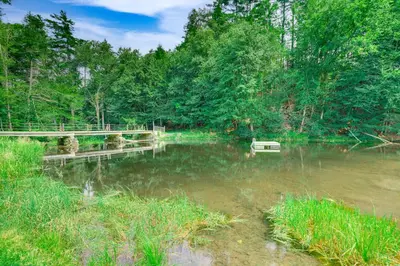 a bridge over a river with a boat in the water at Hawley Home with Deck and Mtn Views Swim, Ski and More! in Hawley