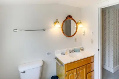 a bathroom with a toilet and a sink and a mirror at Hawley Home with Deck and Mtn Views Swim, Ski and More! in Hawley