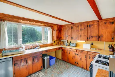 a kitchen with wooden cabinets and a sink and a window at Hawley Home with Deck and Mtn Views Swim, Ski and More! in Hawley