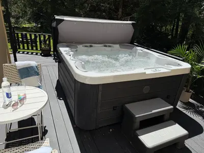 a hot tub sitting on top of a deck at Bethel Escape Hot Tub 4 beds Game Room and Fire pit Fully Stocked Kitchen in Smallwood