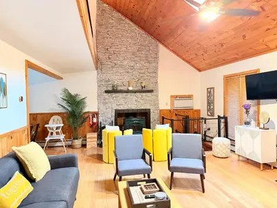 a living room with a couch and a fireplace at Bethel Escape Hot Tub 4 beds Game Room and Fire pit Fully Stocked Kitchen in Smallwood