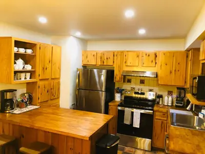 a kitchen with wooden cabinets and a stainless steel refrigerator at Bethel Escape Hot Tub 4 beds Game Room and Fire pit Fully Stocked Kitchen in Smallwood