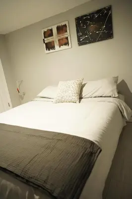a bed in a bedroom with two pictures on the wall at Cozy 2 Bedroom In A Lovely Forest Hills Neighborhood in Parkside