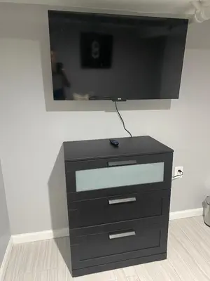 a black dresser with a flat screen tv on a wall at Cozy 2 Bedroom In A Lovely Forest Hills Neighborhood in Parkside
