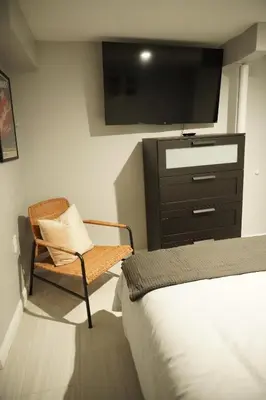 a bedroom with a bed and a chair and a tv at Cozy 2 Bedroom In A Lovely Forest Hills Neighborhood in Parkside