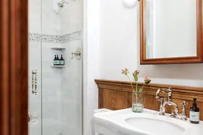 a bathroom with a shower and a sink and a mirror at Private 37 Acre Lake Estate On 164 Acres - 11 Br in Highland