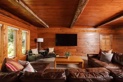 a living room with a couch and a flat screen tv at Private 37 Acre Lake Estate On 164 Acres - 11 Br in Highland