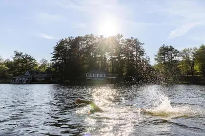 a person is in the water on a lake at Private 37 Acre Lake Estate On 164 Acres - 11 Br in Highland