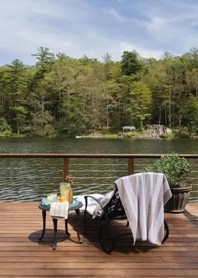 a stroller sitting on a deck next to a body of water at Private 37 Acre Lake Estate On 164 Acres - 11 Br in Highland