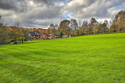 a large green field with a house in the background at Catskill Ski Mountain Retreat with Private Pool in Big Indian