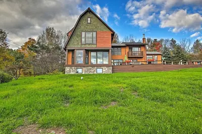 a large house on a hill with a green field at Catskill Ski Mountain Retreat with Private Pool in Big Indian