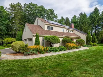 a white house with a landscaping in a yard at Green Utopia in New Canaan