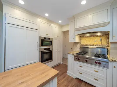 a kitchen with white cabinets and a stove top oven at Green Utopia in Wilton